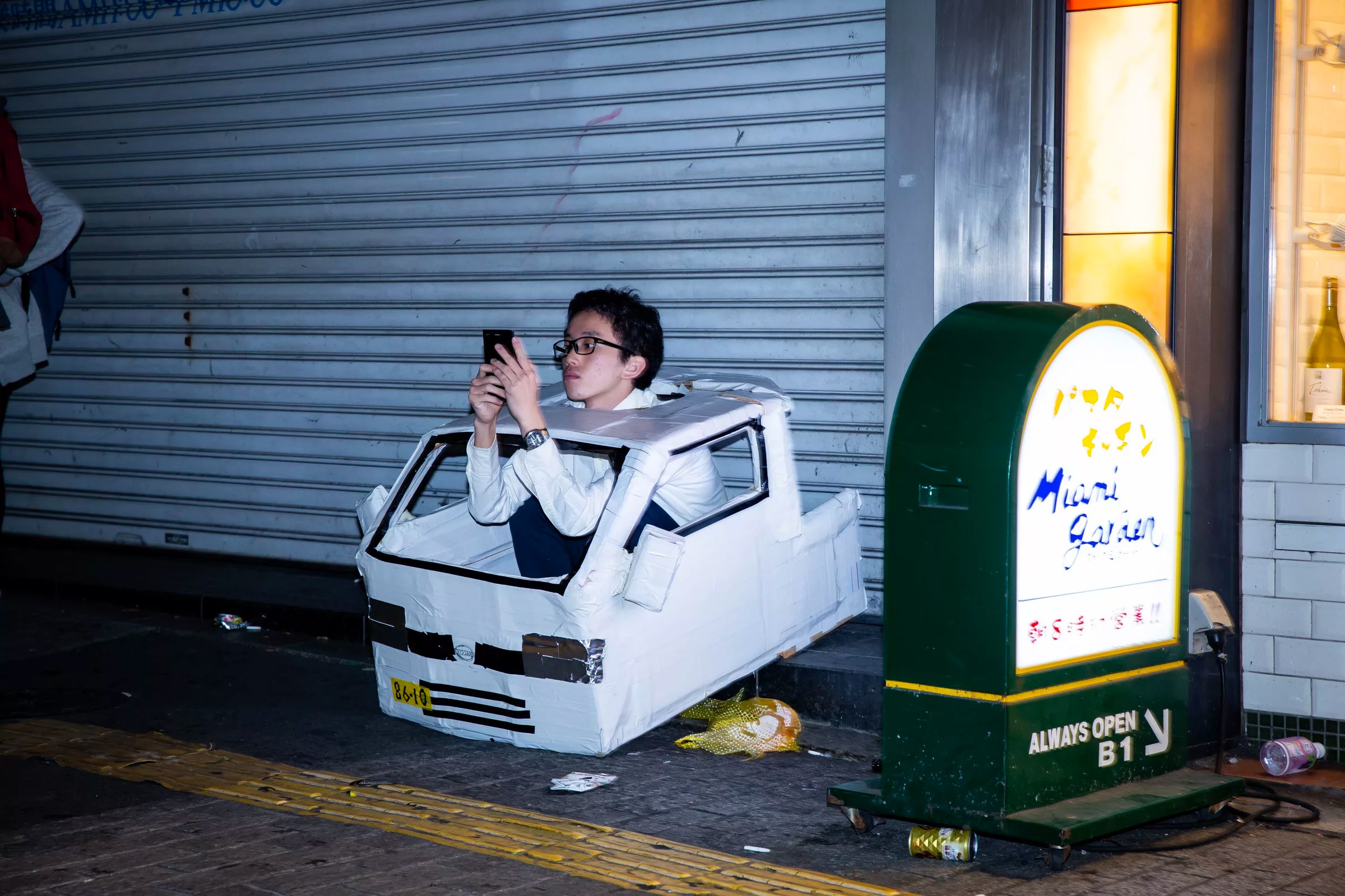 18渋谷ハロウィンで車の仮装して座り込んでるメガネの男性が寂しそう